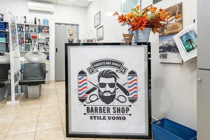 Quadro con il logo Barber Shop Stile Uomo e i pali da barbiere